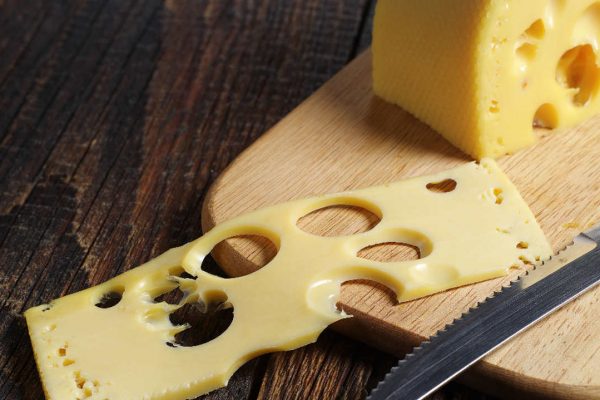 teoria do queijo suíço - fatia de queijo sobre uma tábua