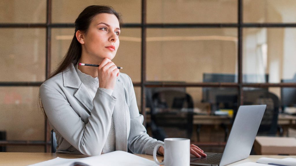 mulher diante de computador com postura pensativa mentalidade de riscos ISO 9001