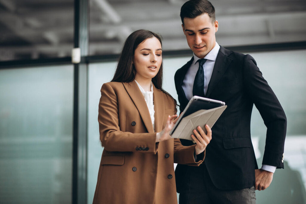 homem e mulher com tablet conversam alinhando sobre consultoria de sgq iso 10019